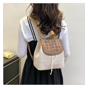 Bohemian woven straw backpack with colorful geometric flap shown on a model's back