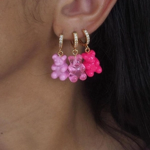 Three pairs of gummy bear hoop earrings in various shades of pink with gold zircon buckles