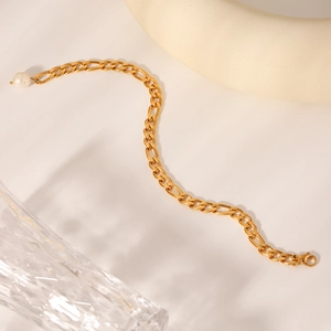 Detail of 18K gold stainless steel Figaro anklet with freshwater pearl charm and clasp