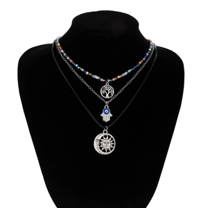 Detail view of multi-layered beaded necklaces with Tree of Life and Hand of Fatima pendants