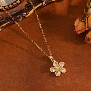 Détail d'un collier fleur avec cristaux clairs sur une chaîne en acier doré