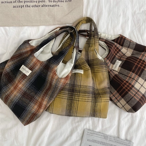 Vista piatta di tre borse tote a scacchi vintage nei colori marrone, giallo e arancione
