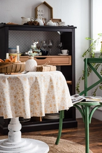 Detailed close-up of cream round tablecloth with golden Christmas snowflake patterns