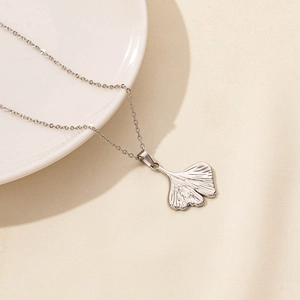 Detail of silver ginkgo leaf pendant with delicate veins on stainless steel chain