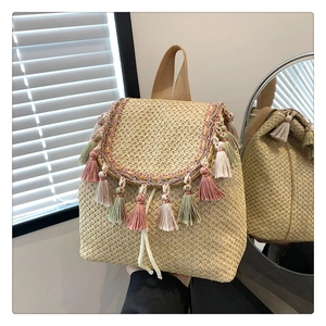 Macro detail of hand-woven straw backpack with colorful hanging tassels and texture
