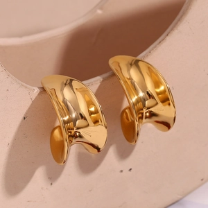 Détail des boucles d'oreilles dorées courbes avec le logo S925 gravé à l'intérieur