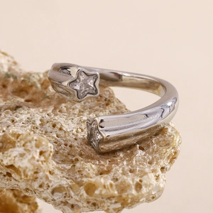Macro detail of silver-toned star ring featuring sparkling cubic zirconia on stone base