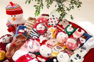 Detailed view of Christmas coral fleece socks with 3D cartoon motifs in a festive gift box