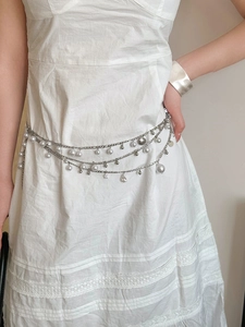 Detail of silver layered waist chain with pearls, shells and starfish charms for women