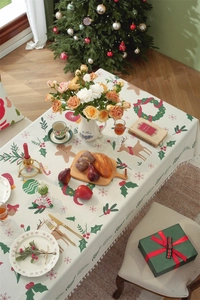 Close-up of beige Christmas tablecloth with reindeer and snowflake prints and tassel edges
