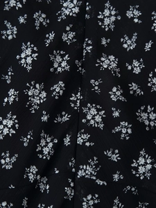 Gros plan sur un tissu mousseline noir à fleurs avec des détails de couture de précision