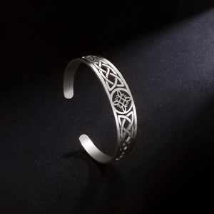 Close-up of vintage silver stainless steel cuff featuring intricate Celtic knot cutouts