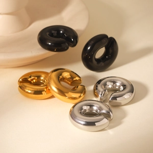 Detailed view of C-shaped chunky ear cuffs in polished gold, silver and black finishes