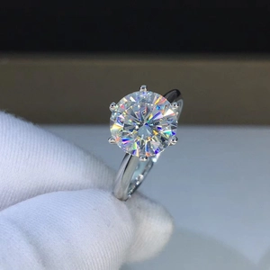 Close-up of a classic six-prong crown ring featuring a brilliant round moissanite stone