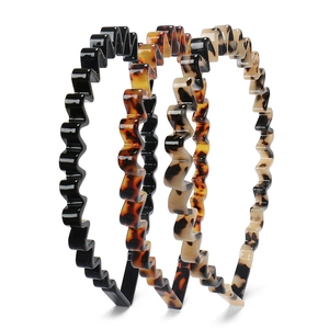 Close-up of three 8mm wavy cellulose acetate headbands in black and tortoise shell patterns