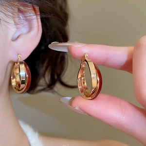 Detail of vintage gold layered hoop earrings with deep burgundy enamel finish