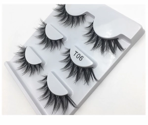 Close-up of five pairs of thick cross-style false eyelashes in a white T06 tray