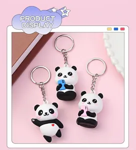 Detail von süßen Panda-Schlüsselanhängern mit Mini-Telefonen auf rosa Hintergrund