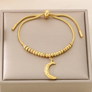 Detail of gold beaded bracelet with moon charm on a premium jewelry display box