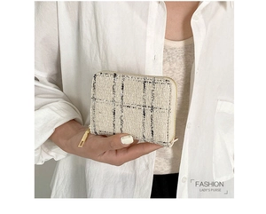 Detail of tweed fabric texture and golden zipper on cream white small wallet