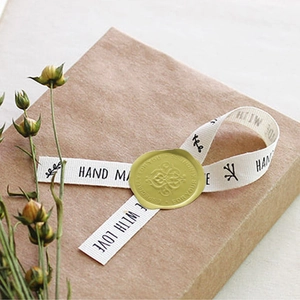 Brown kraft gift box tied with handmade white ribbon and gold wax seal sticker