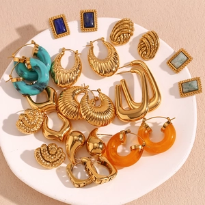 Flat lay of vintage 18K gold plated hollow earrings with blue resin and stone inlays
