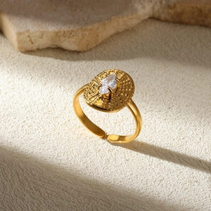 Macro shot of gold hammered adjustable ring with marquise crystal on textured backdrop