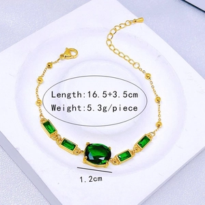 Détail d'un bracelet en acier titane doré avec pierres vert émeraude et mesures