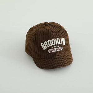 Nahaufnahme der dunkelbraunen Cordstruktur und Brooklyn-Stickerei auf der Babykappe