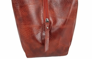Detail of lychee pattern leather surface with retro stitching and metal rivet zipper