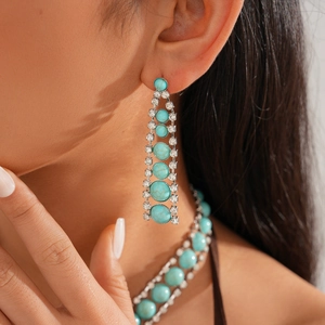 Close-up of blue turquoise beaded necklace and drop earrings with silver diamond accents