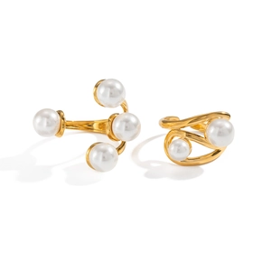 Macro detail of gold geometric ring with round white pearls and polished streamlined band
