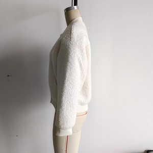 Détail d'une veste courte blanche en polaire bouclée montrant la texture sur mannequin