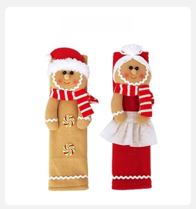Front view of plush gingerbread man refrigerator handle covers with festive red scarves