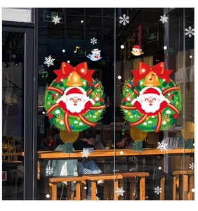 Detail of Christmas window clings with Santa Claus wreaths and snowflakes on glass