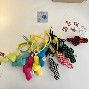 Close-up of colorful checkered fabric knot bag charms with spiral cord attachments
