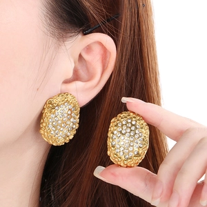 Golden oval hoop earrings with sparkling rhinestones and textured rock surface design