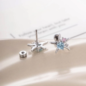 Silver starfish stud earrings featuring light blue heart stones and pink crystal accents