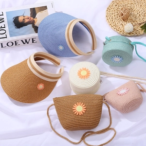 Detailed view of woven straw sun hats and mini crossbody bags with 3D daisy appliqués