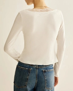 Close-up of fine ribbed knit texture and delicate white lace trim on the collar back