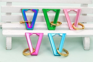 Detail of colorful V-shaped drop earrings in five vibrant shades on mini wooden bench