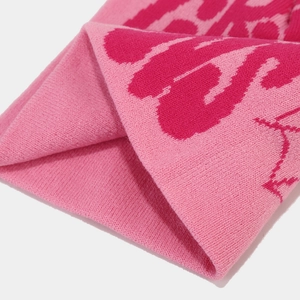 Macro shot of pink jacquard knit fabric showing detailed thick weave and soft texture
