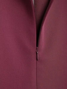 Close-up of wine red twill fabric texture and invisible zipper detail on short dress