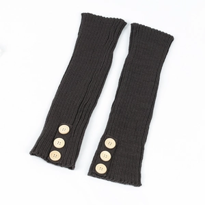 Close-up of black knitted leg warmers featuring ribbed texture and decorative wood buttons