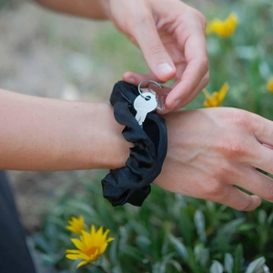 Detail showing invisible zipper pocket on black scrunchie for keys and storage