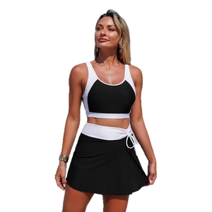 Two-piece color block swimwear set with a black and white bikini top and skirted bottom