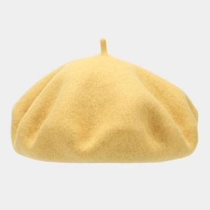 Detail of a vintage ginger yellow wool beret with soft felt texture and classic top stem