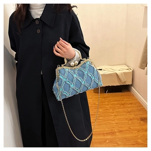 Close-up of blue denim shell bag with gold chain strap and pearl clasp detail