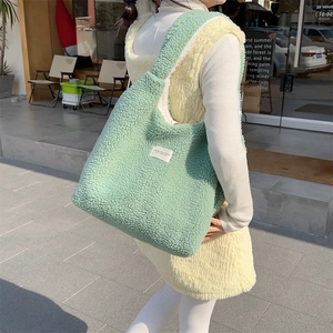 Detail of mint green sherpa tote bag with textured fleece and minimalist woven label