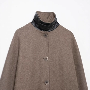 Minimalist tan wool coat with black leather contrast collar and large round buttons